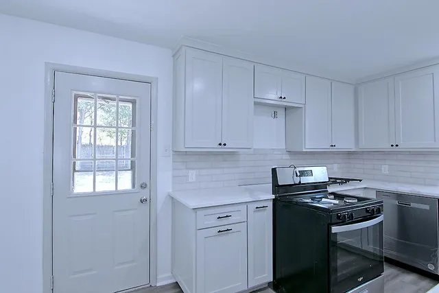 a kitchen with stainless steel appliances white cabinets and sink