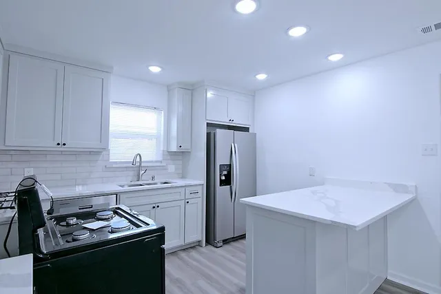 a kitchen that has a sink stainless steel appliances a counter space and cabinets