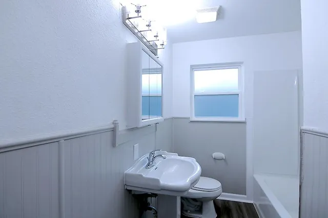a bathroom with a sink a toilet and mirror