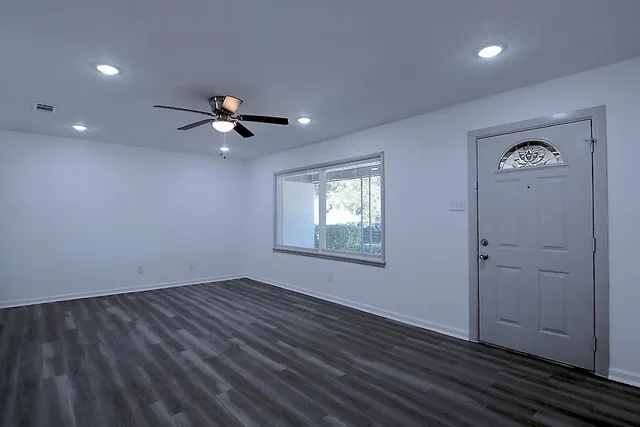 wooden floor in an empty room with a window