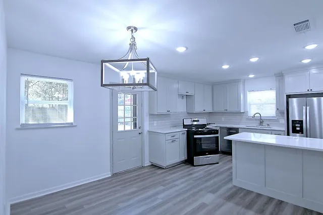 a kitchen with a stove and white cabinets