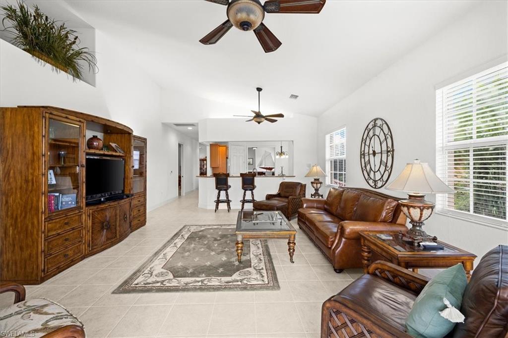 6443 Legacy Circle, Unit 1103 Naples, FL 34113 - Photo 16 of 35 a living room with furniture a rug and a flat screen tv