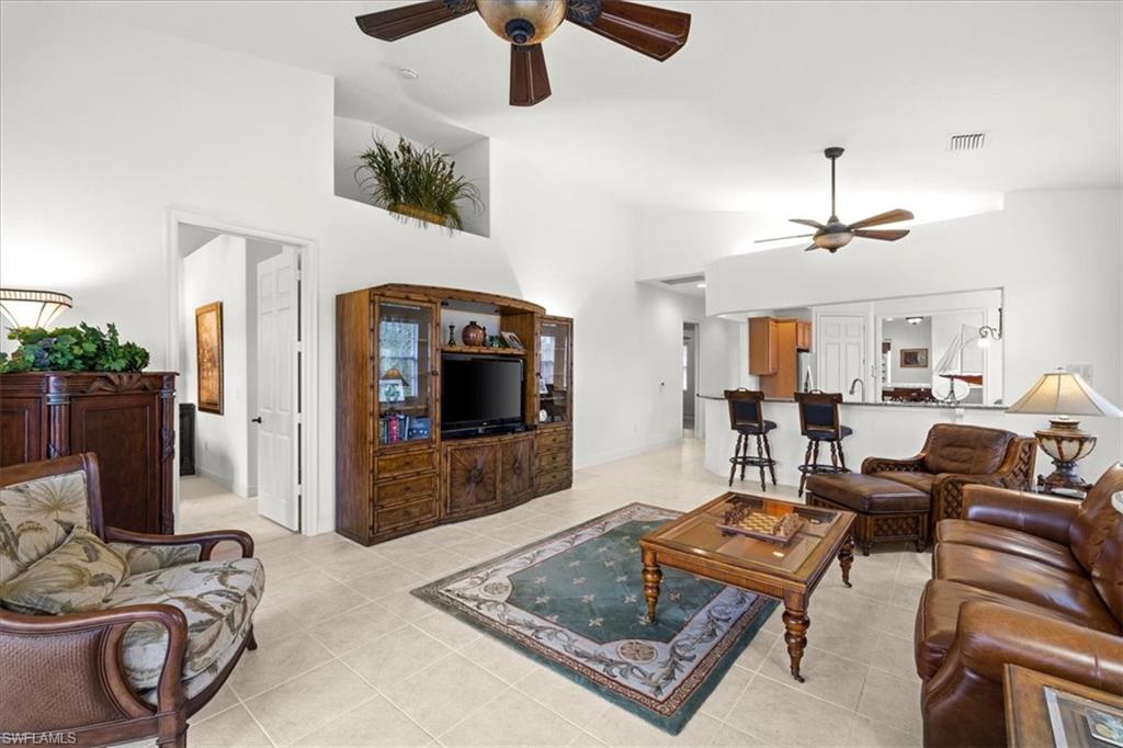 6443 Legacy Circle, Unit 1103 Naples, FL 34113 - Photo 18 of 35 a living room with furniture and a flat screen tv