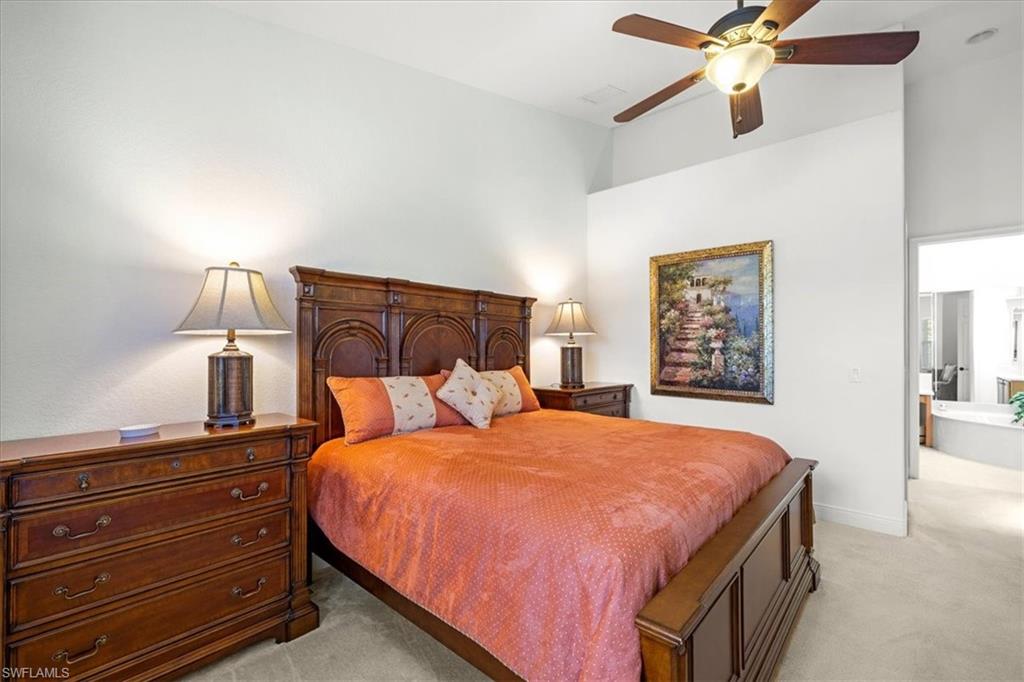 6443 Legacy Circle, Unit 1103 Naples, FL 34113 - Photo 21 of 35 a bedroom with a bed and a lamp