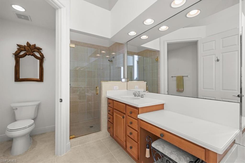 6443 Legacy Circle, Unit 1103 Naples, FL 34113 - Photo 23 of 35 a bathroom with a sink a toilet and mirror