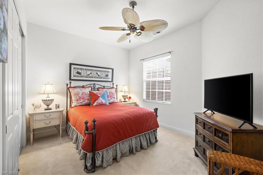 6443 Legacy Circle, Unit 1103 Naples, FL 34113 - Photo 29 of 35 a bedroom with a bed and a flat tv screen on dresser