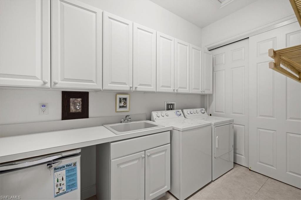 6443 Legacy Circle, Unit 1103 Naples, FL 34113 - Photo 31 of 35 a view of a kitchen with white cabinets and sink