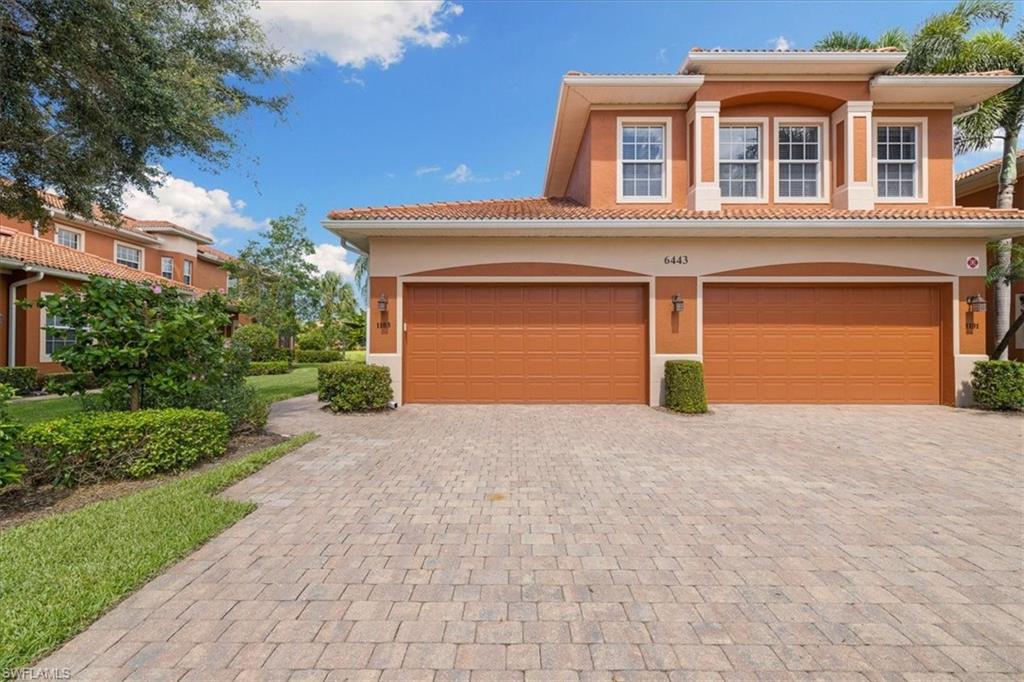 6443 Legacy Circle, Unit 1103 Naples, FL 34113 - Photo 6 of 35 a front view of a house with a yard and a garage