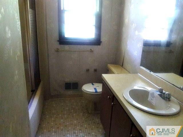 18 Ash Road Edison, NJ 08817 - Photo 18 of 25 a bathroom with a toilet a sink and mirror