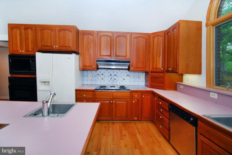 6425 Lignum Street Springfield, VA 22150 - Photo 23 of 30 a kitchen with granite countertop wooden cabinets a sink and dishwasher