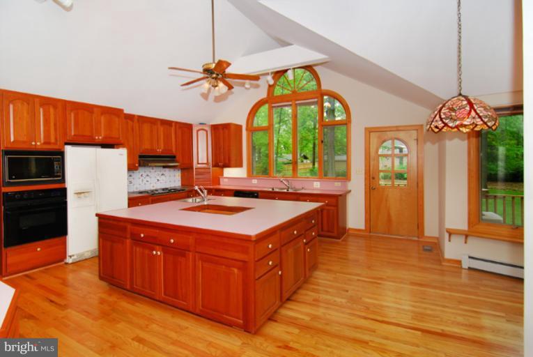 6425 Lignum Street Springfield, VA 22150 - Photo 9 of 30 a kitchen with a stove a refrigerator and a dining table