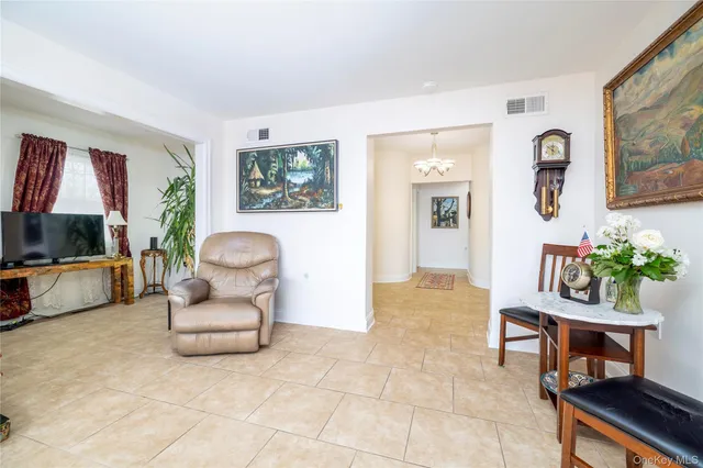 a living room with furniture a flat screen tv and a potted plant