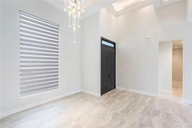 a large white kitchen with a large counter top a sink and stainless steel appliances