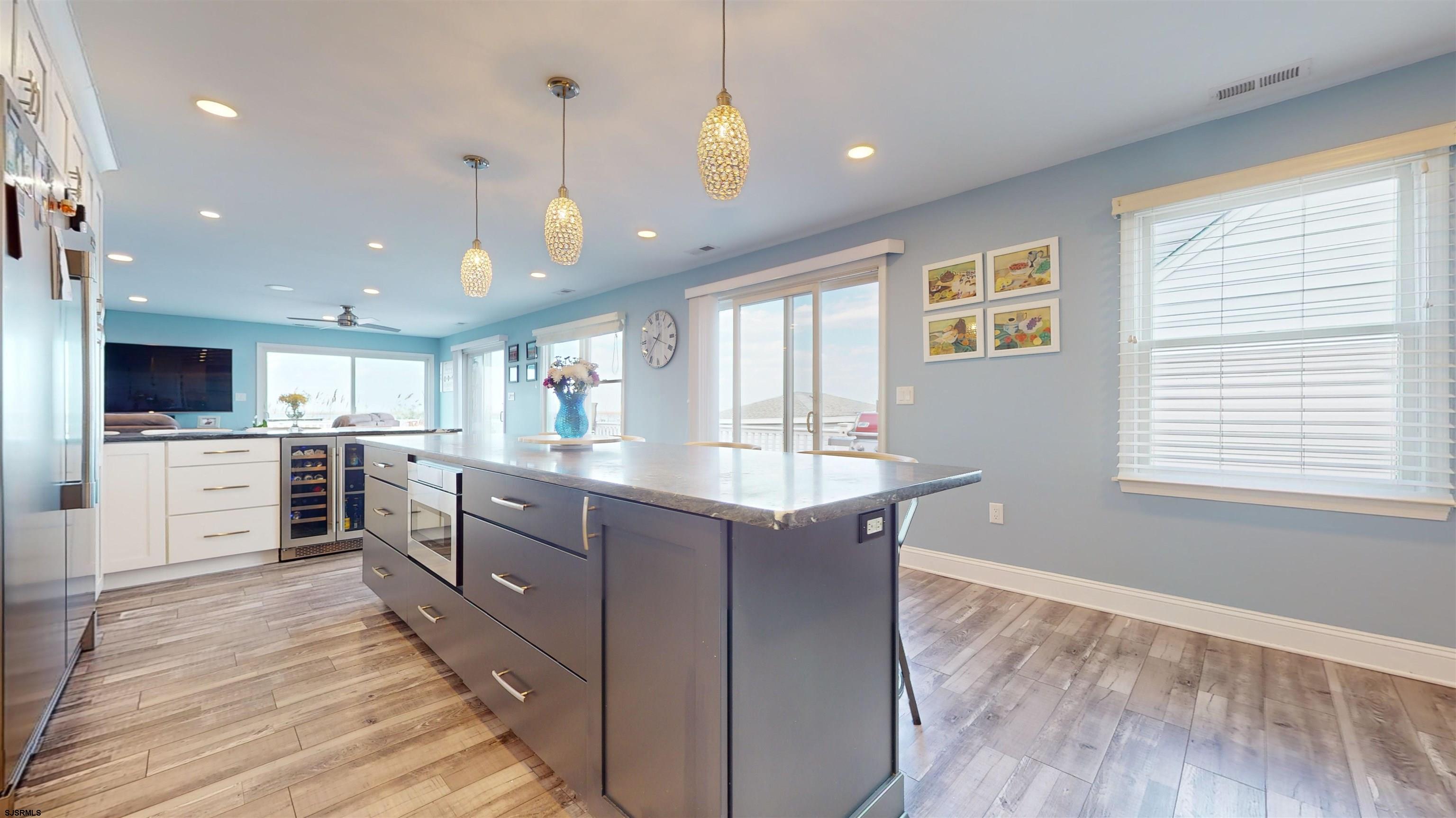 4205 Atlantic Brigantine Boulevard Brigantine, NJ 08203 - Photo 21 of 58 a kitchen with stainless steel appliances kitchen island granite countertop a stove top oven a sink dishwasher a dining table and chairs with wooden floor