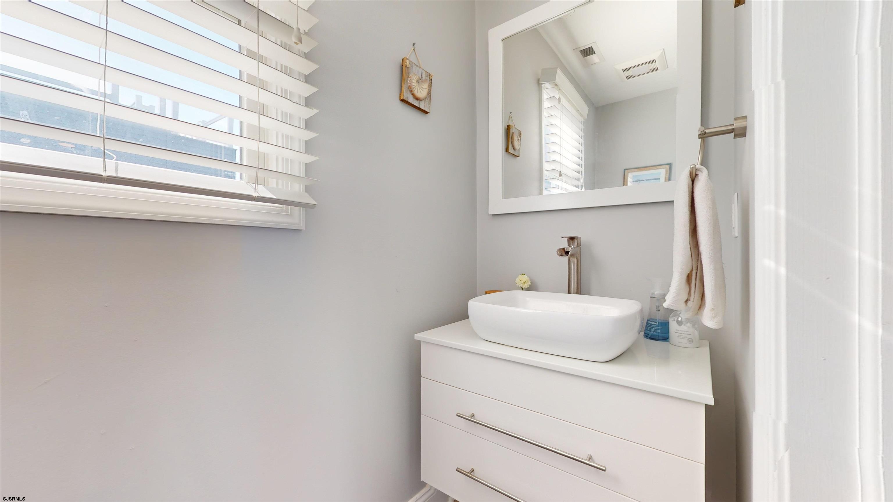4205 Atlantic Brigantine Boulevard Brigantine, NJ 08203 - Photo 44 of 58 a bathroom with a sink a toilet and a mirror