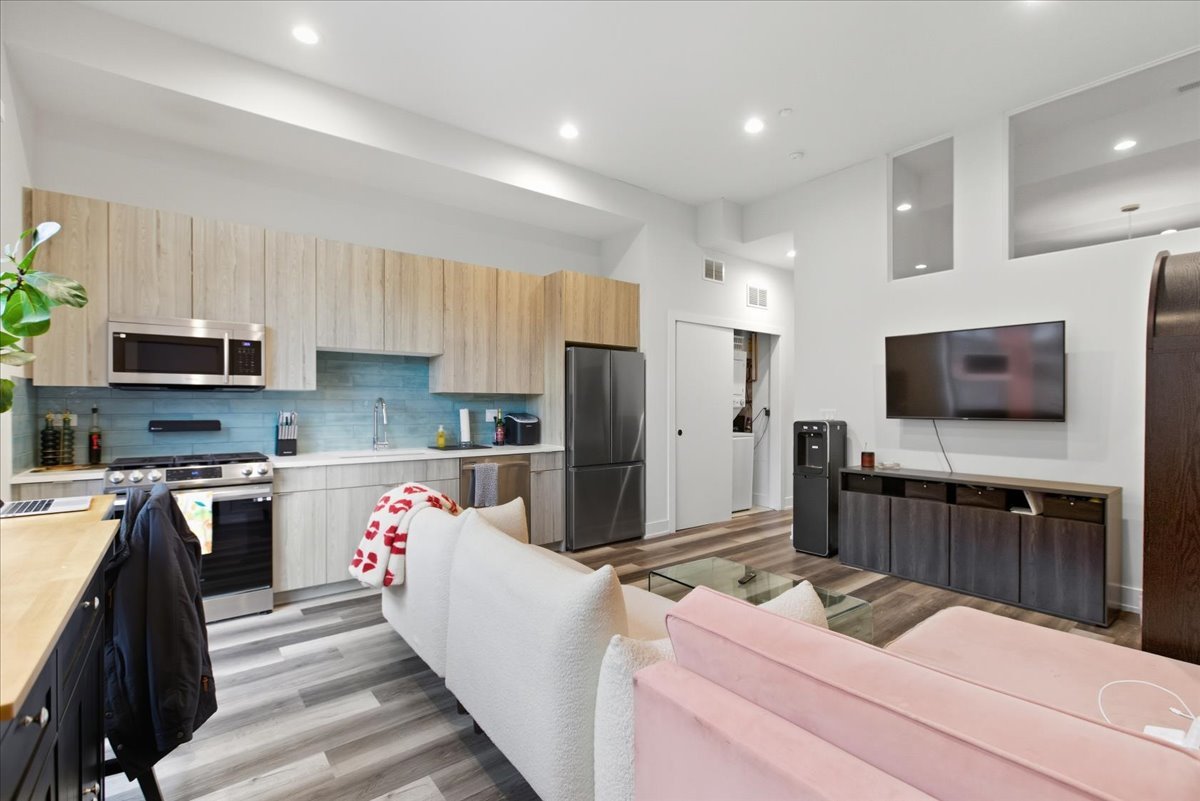 2317 North Clark Street, Unit 410 Chicago, IL 60614 - Photo 5 of 16 a kitchen with stainless steel appliances kitchen island granite countertop a refrigerator stove microwave and sink