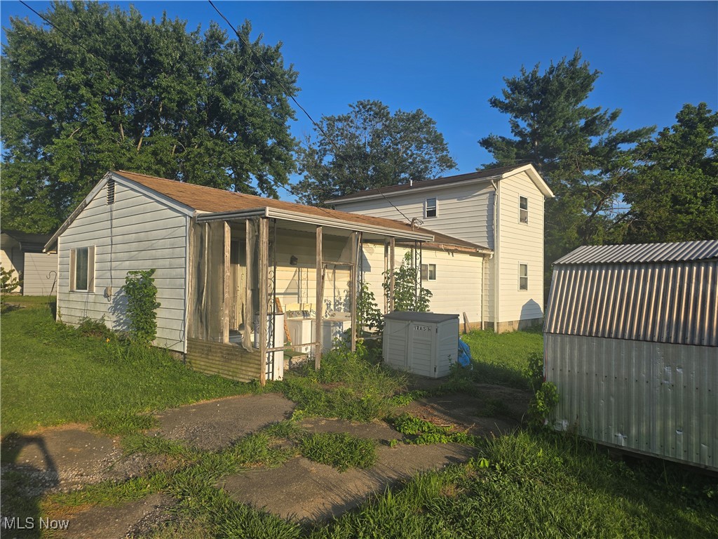 73 Locust Rutland, OH 45775 - Photo 1 of 4 View of home's exterior with a sunroom and an outdoor structure