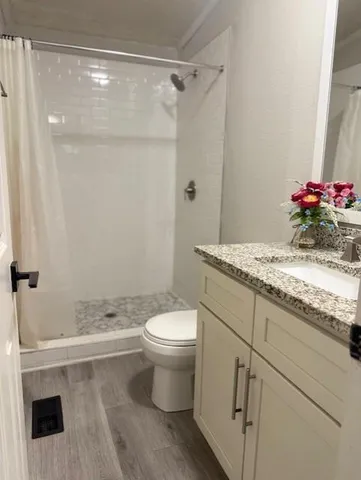 a bathroom with a granite countertop sink toilet and shower