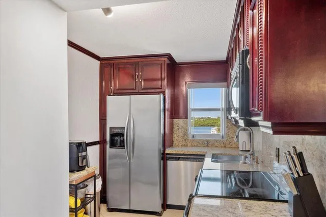a kitchen with stainless steel appliances granite countertop a refrigerator and a sink
