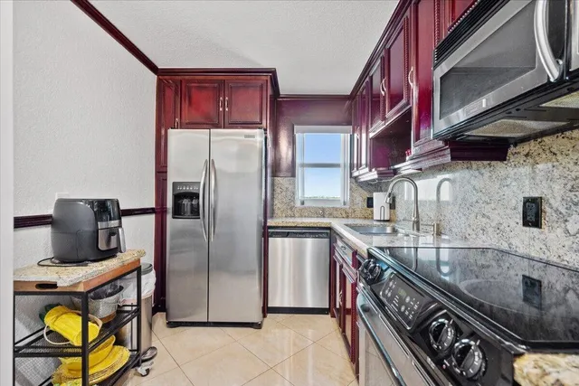 a kitchen with stainless steel appliances granite countertop a stove a refrigerator and a sink