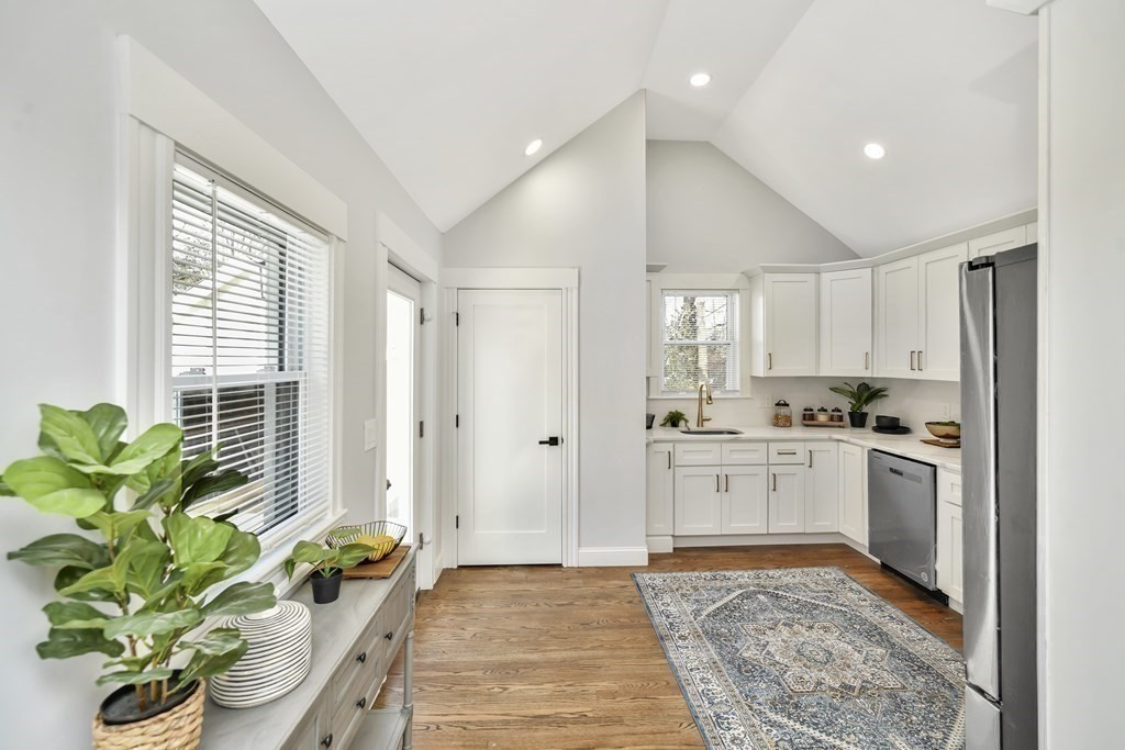 234 Rockland Street Canton, MA 02021 - Photo 8 of 38 a large white kitchen with a stove a sink a rug and a window
