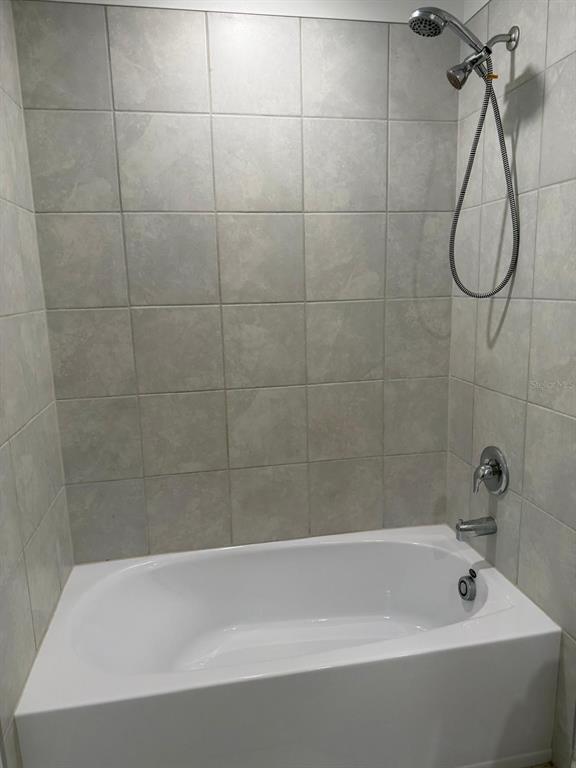 693 Reggie Road Winter Haven, FL 33859 - Photo 14 of 17 a bathroom with a bath tub with a shower