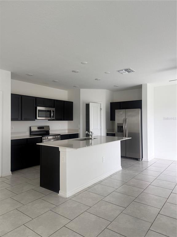 693 Reggie Road Winter Haven, FL 33859 - Photo 8 of 17 a large kitchen with cabinets and stainless steel appliances