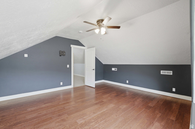 2567 West Rim Rock Drive Stockton, UT 84071 - Photo 37 of 64 Spacious room featuring wood-finish flooring, a ceiling fan, and sloped ceilings