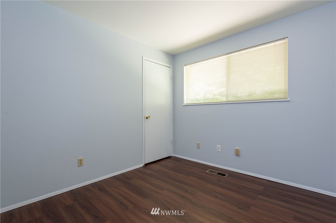 4131 Northeast 19th Street Renton, WA 98059 - Photo 25 of 40 a view of an empty room with wooden floor and a window