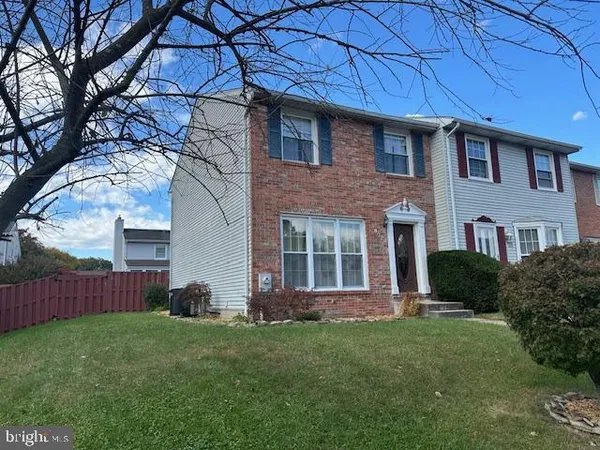 a brick house with a large window and a yard