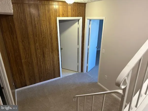 a view of an empty room with window and chandelier fan