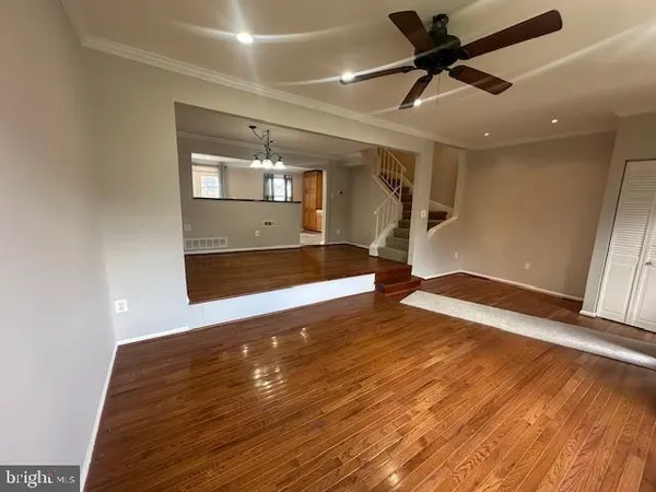 a view of a room with wooden floor and chandelier