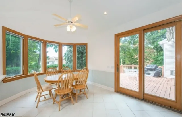 a dining room with furniture and large windows