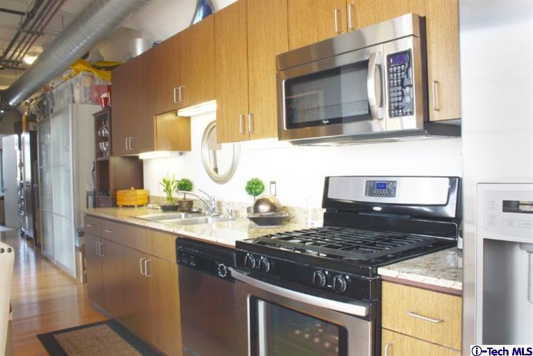 200 North San Fernando Road, Unit 314 Lincoln Heights, CA 90031 - Photo 9 of 28 a kitchen with stainless steel appliances granite countertop a stove and a microwave