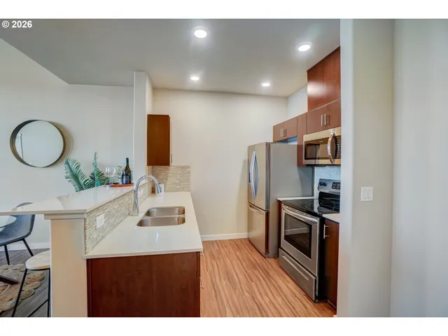 a kitchen with stainless steel appliances a refrigerator and a stove top oven