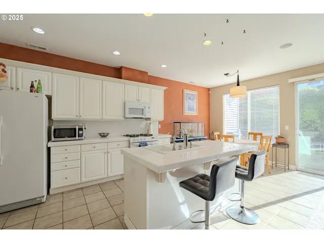 a kitchen with stainless steel appliances kitchen island granite countertop a sink and cabinets