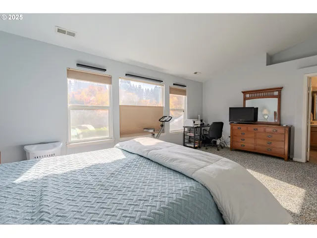 a bedroom with a bed mirror and window