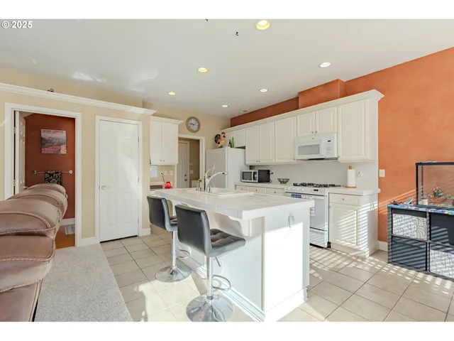 a kitchen with white cabinets and refrigerator