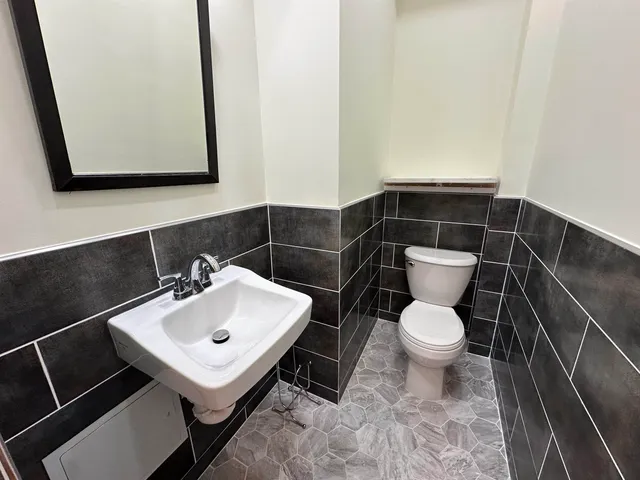 a bathroom with a sink toilet and mirror
