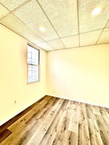 a view of a room with wooden floor and a window