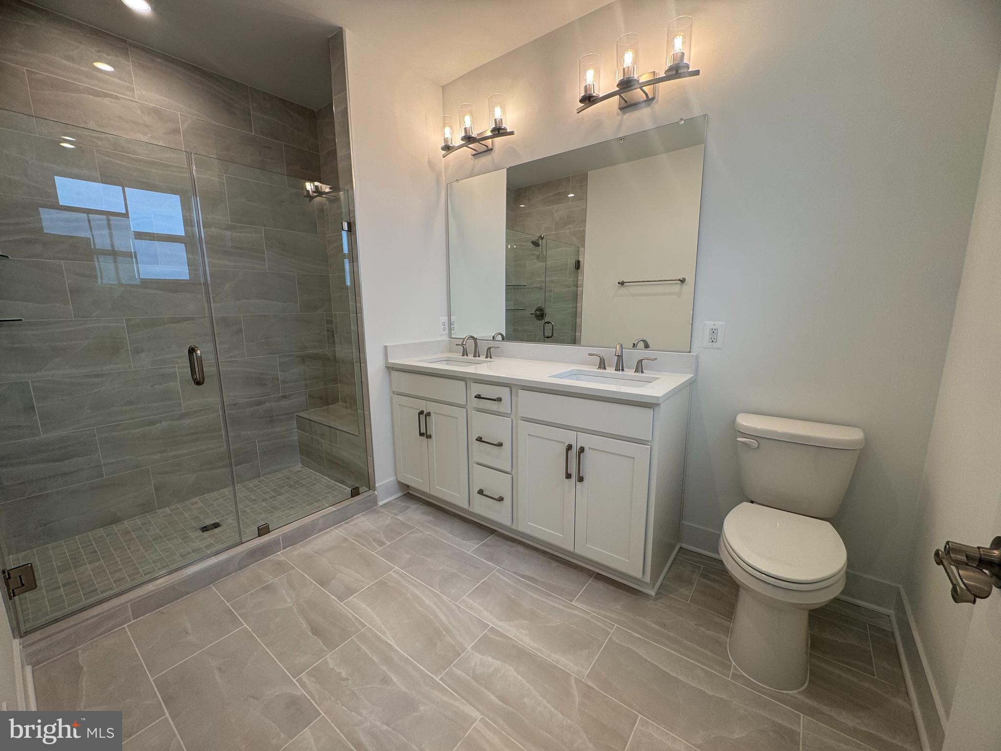 82 Valerian Loop, Unit 2 Stafford, VA 22554 - Photo 11 of 55 a bathroom with a toilet a sink a mirror and shower