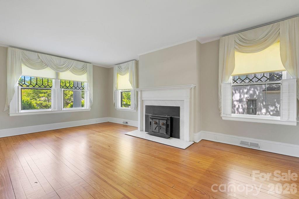 208 West Probart Street Brevard, NC 28712 - Photo 14 of 48 wooden floor fireplace and windows in an empty room