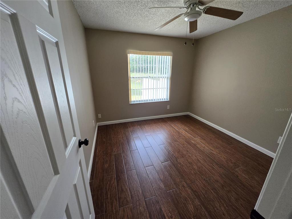 7607 Benji Ridge Trail Kissimmee, FL 34747 - Photo 12 of 58 a view of an empty room with wooden floor and a window