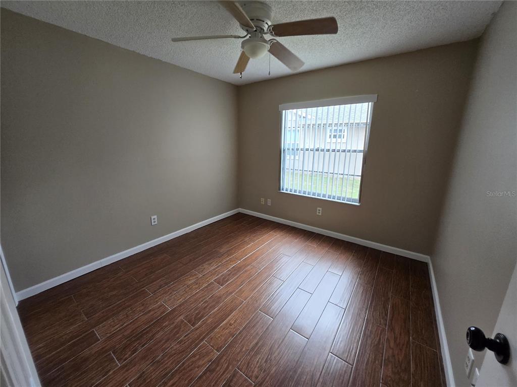 7607 Benji Ridge Trail Kissimmee, FL 34747 - Photo 14 of 58 an empty room with wooden floor and windows
