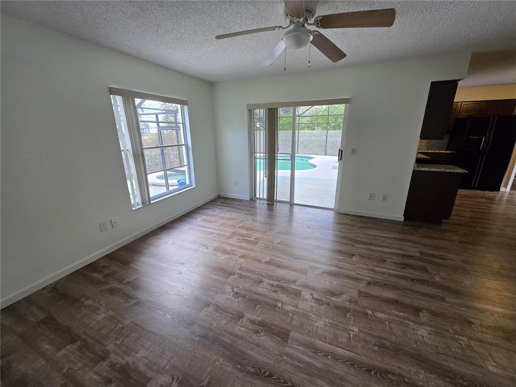7607 Benji Ridge Trail Kissimmee, FL 34747 - Photo 16 of 58 an empty room with wooden floor fan and windows