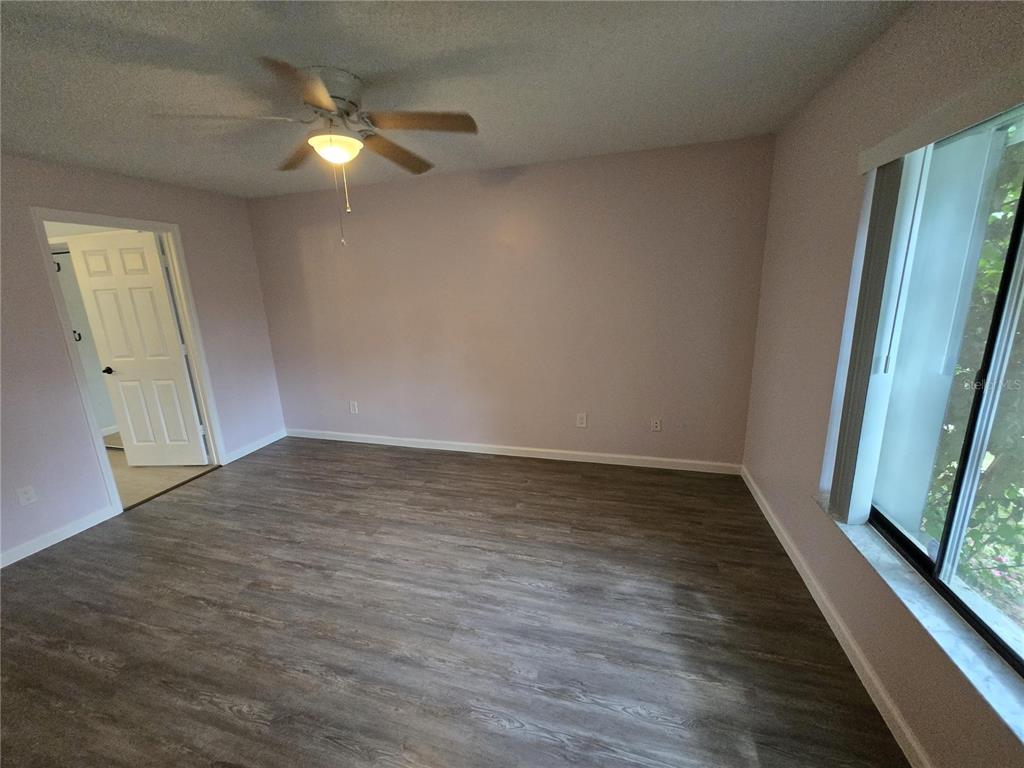 7607 Benji Ridge Trail Kissimmee, FL 34747 - Photo 34 of 58 an empty room with wooden floor and fan