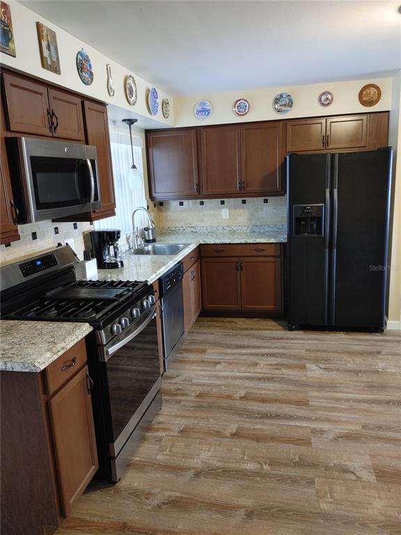 7607 Benji Ridge Trail Kissimmee, FL 34747 - Photo 5 of 58 a kitchen with stainless steel appliances granite countertop a stove and a sink