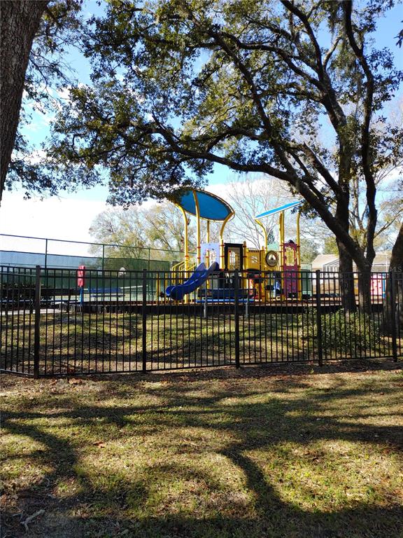 7607 Benji Ridge Trail Kissimmee, FL 34747 - Photo 56 of 58 a view of a swimming pool with a bench and trees