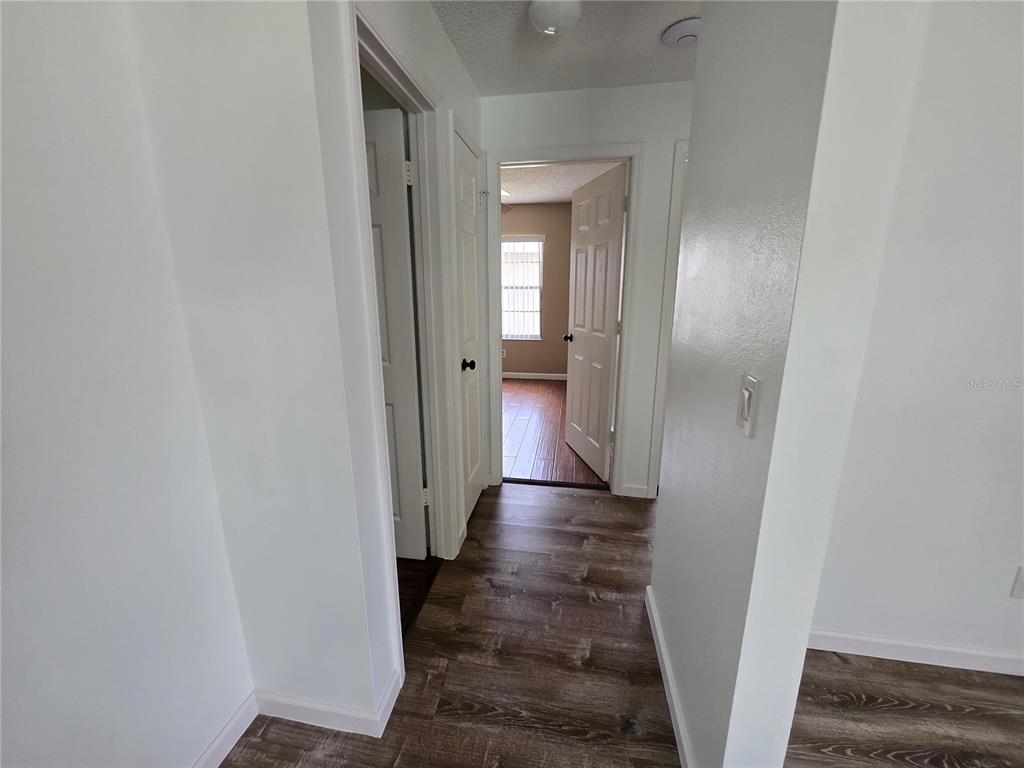 7607 Benji Ridge Trail Kissimmee, FL 34747 - Photo 7 of 58 a view of a hallway with a livingroom and a bathroom with sink