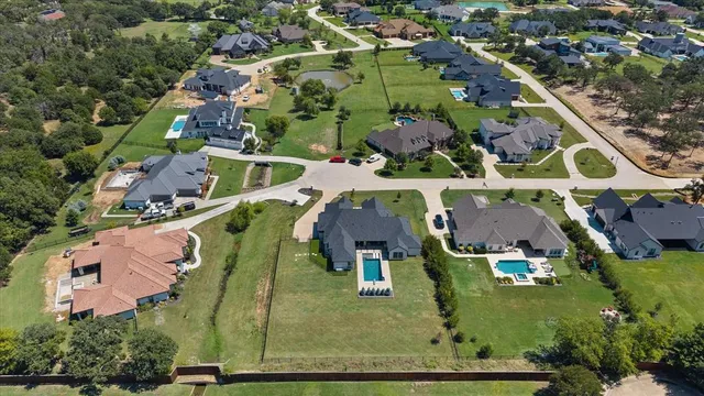an aerial view of residential houses with outdoor space and parking